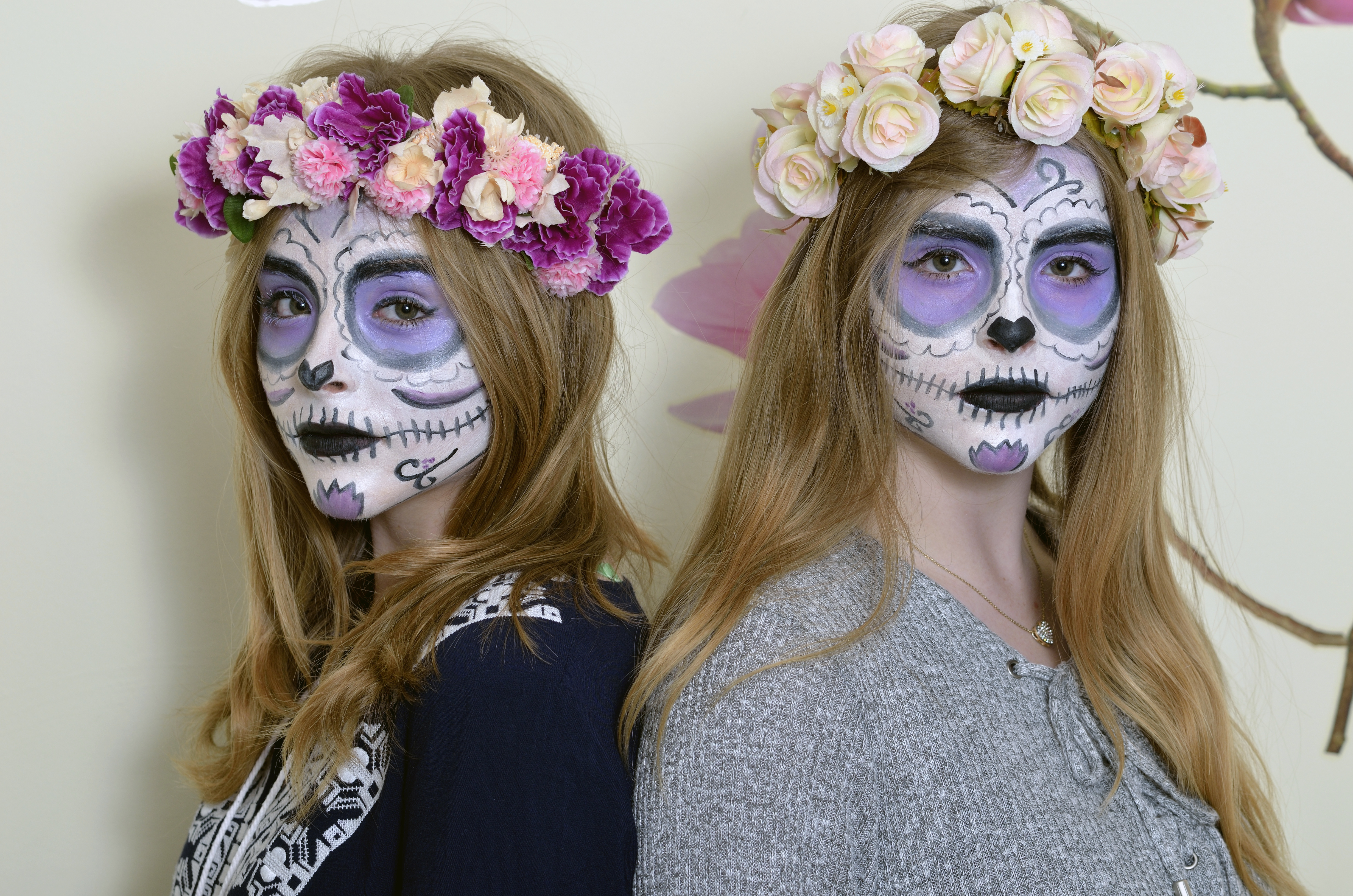 Halloween two blonde girls with makeup Mexican death mask and with a wreath of flowers